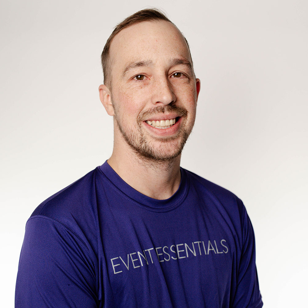 Headshot of Anthony Dring in a purple Event Essentials T-shirt.