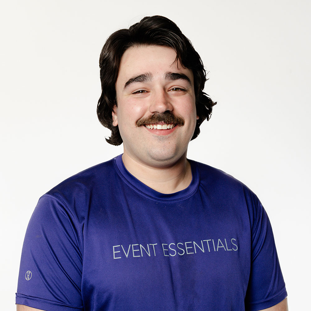 Headshot of Tyler Romaine in a purple Event Essentials polo.